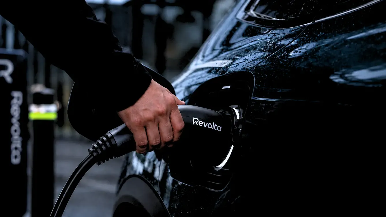 Persona conectando un vehículo eléctrico